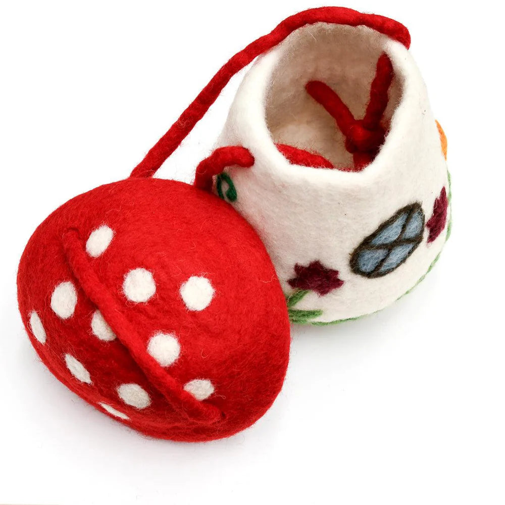 Close-up of felt mushroom bag with lid open, showing soft wool interior and whimsical embroidered details.