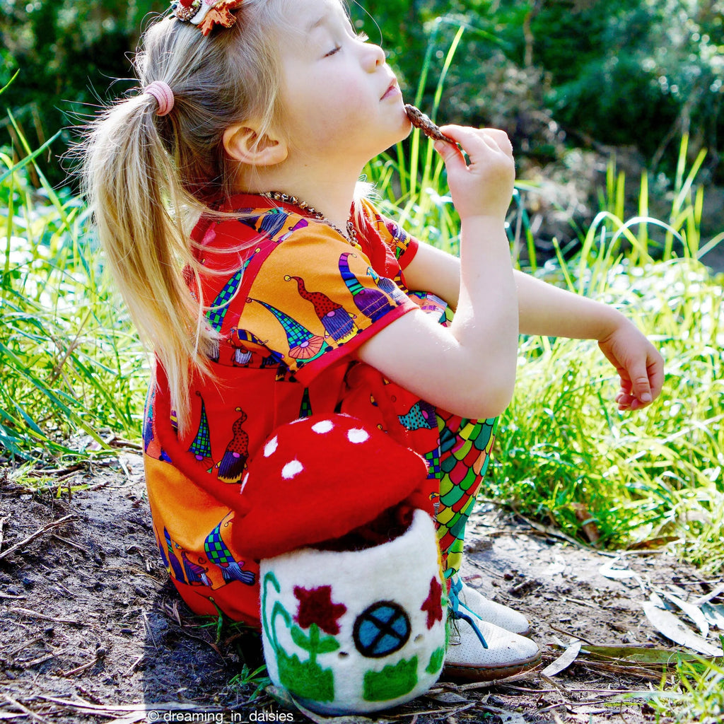 Child playing outdoors, wearing the mushroom bag as a crossbody, ideal for pretend play and adventure.