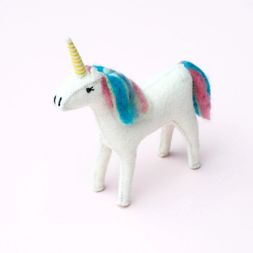 Side view of small handcrafted felt unicorn with pastel rainbow-coloured mane and tail.