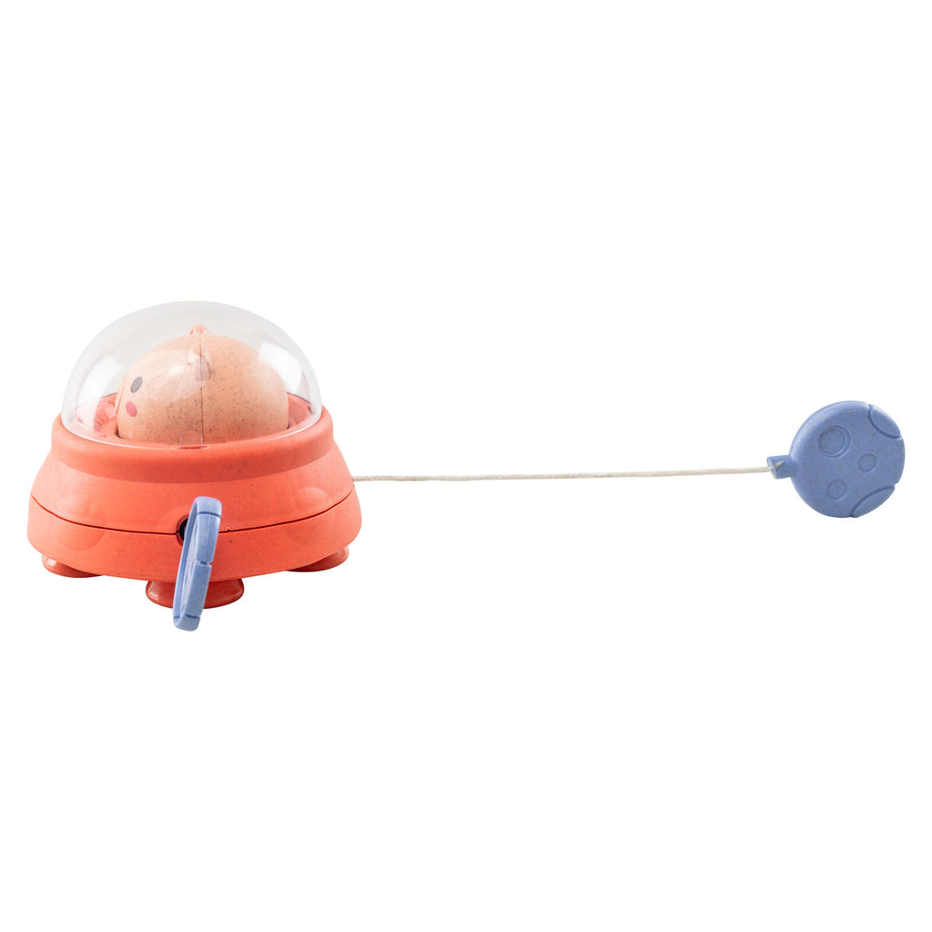 Space Piggy bath toy with paddle fully extended, showing the pull-string feature that activates paddling movement in the water.