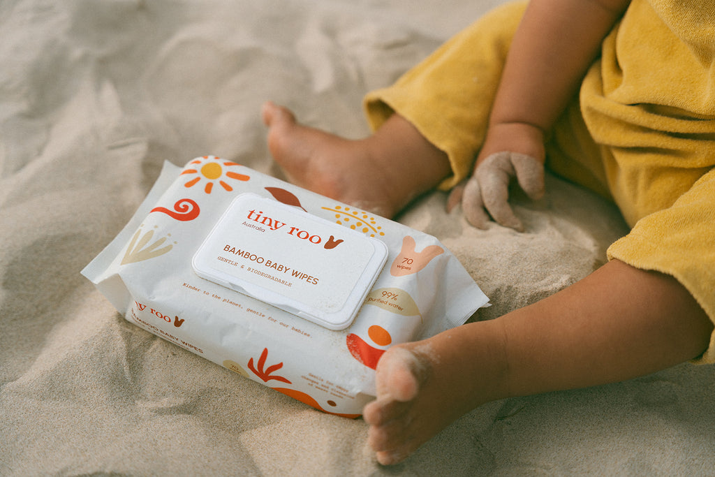 Child holding a pack of Tiny Roo bamboo baby wipes in a natural outdoor setting, reinforcing biodegradable and travel-friendly design.