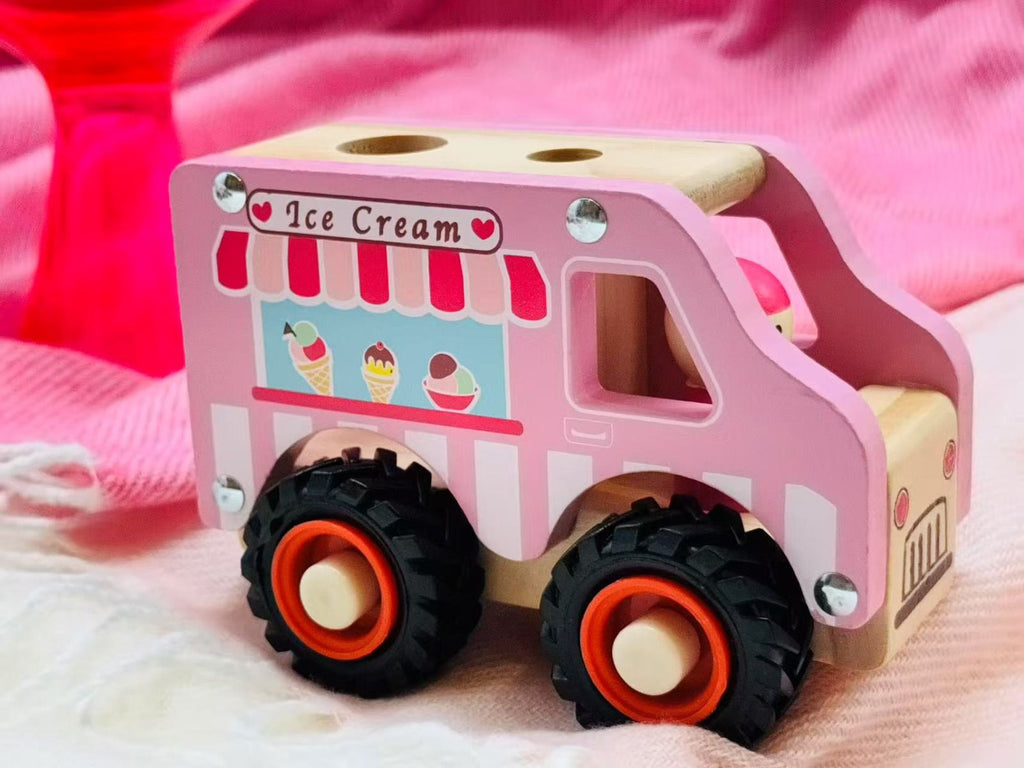 Wooden toy ice cream truck with pink and red striped awning on a pink background