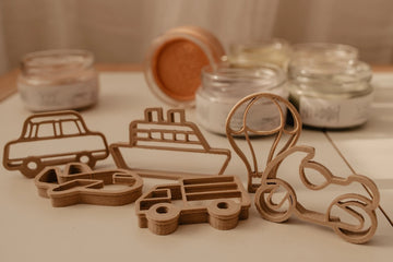 Eco-friendly transport-themed dough cutter set featuring car, truck, plane, motorbike, boat, and hot air balloon, displayed on wooden surface.