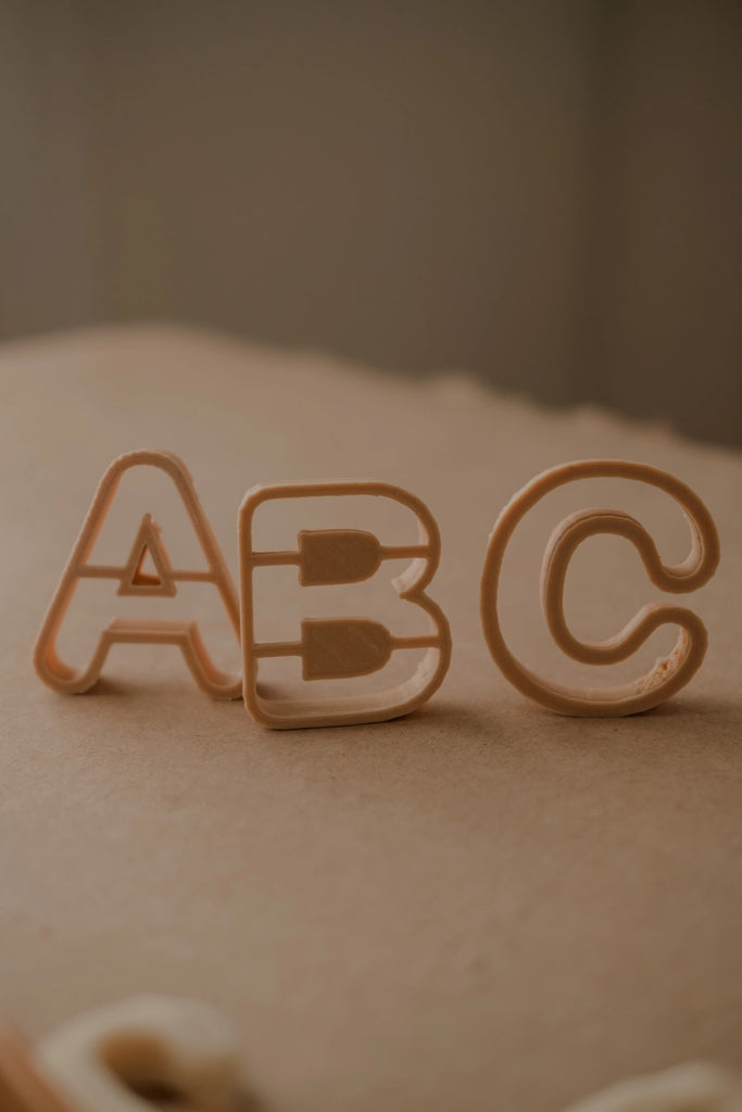 Natural-toned Kinfolk Pantry cutters spelling ABC, styled for play-based learning.