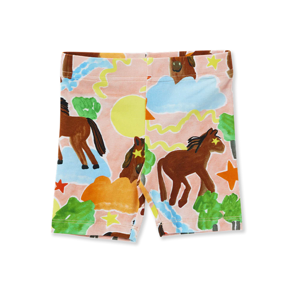 Flat lay of Halcyon Nights Giddy Up Kids Bike Shorts featuring playful horse and landscape print in earthy tones and pastel skies.