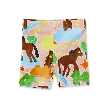 Flat lay of Halcyon Nights Giddy Up Kids Bike Shorts featuring playful horse and landscape print in earthy tones and pastel skies.