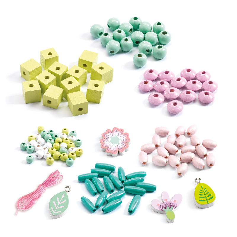 Assortment of 450 wooden beads, charms, and strings in pastel colours laid out on a white background, including leaf and flower shapes.