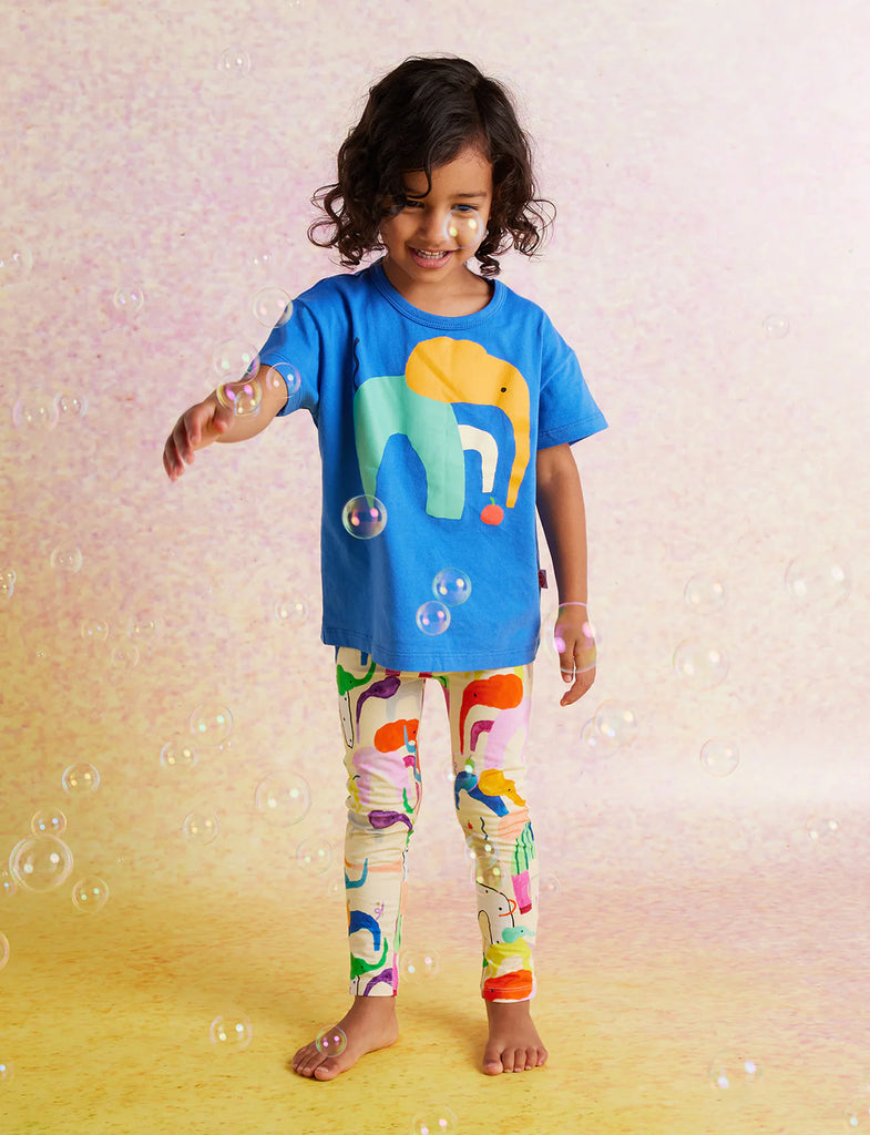 Child wearing Halcyon Nights Happy Herd Kids Leggings and matching blue top, standing playfully with bubbles in the background.